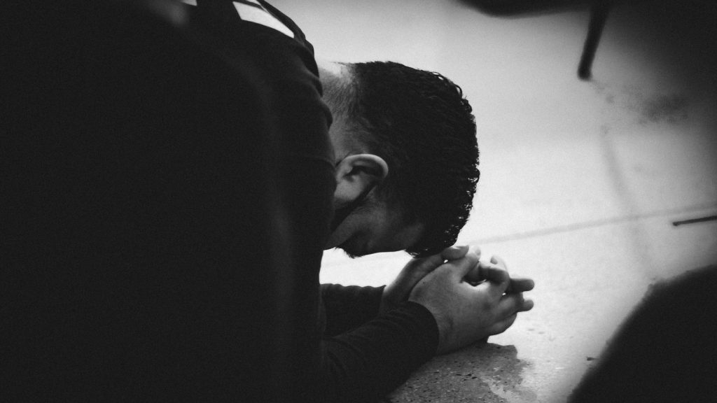 man in black jacket lying on floor