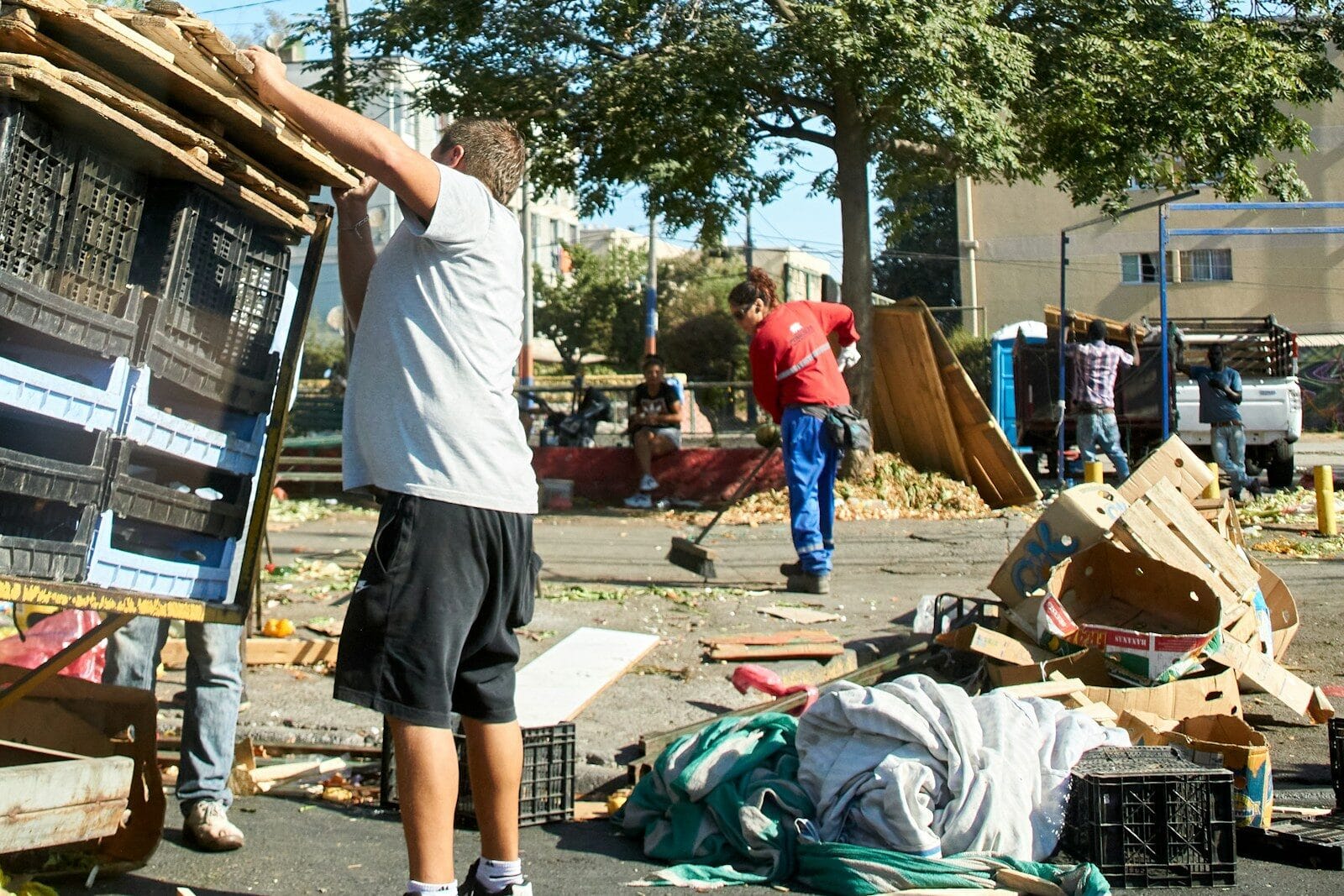 a man standing next to a pile of junk