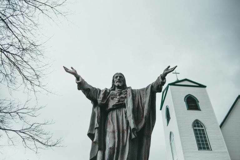man in coat holding stick statue