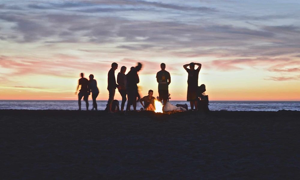 Photo by Kimson Doan group of people setting up campfire