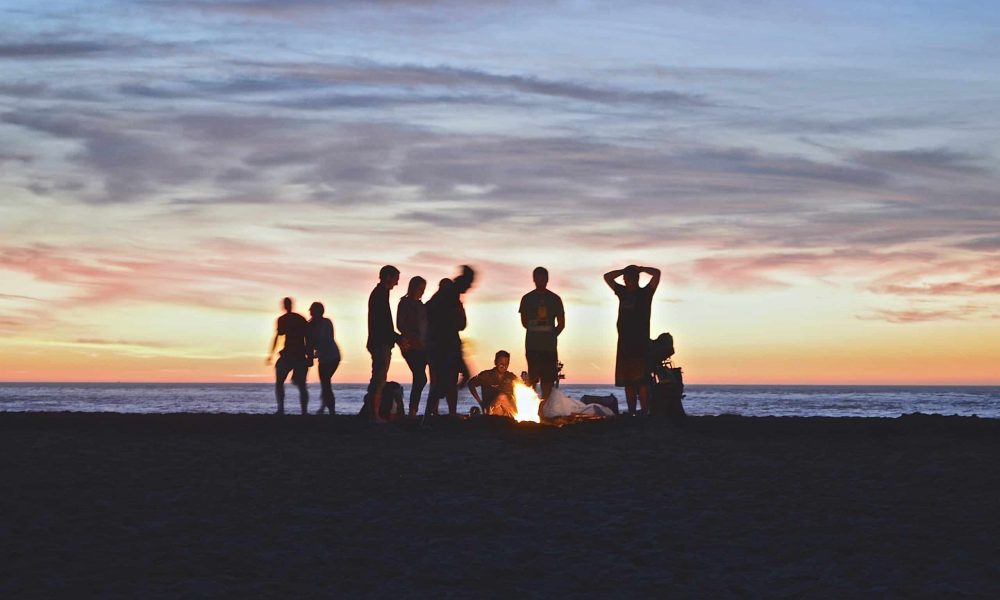 Photo by Kimson Doan group of people setting up campfire
