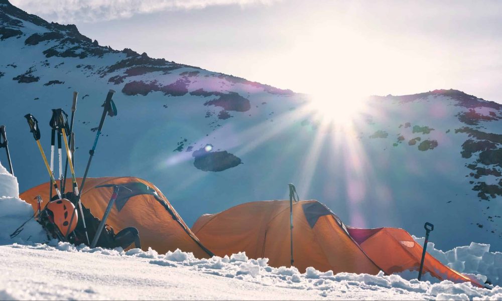 Photo by Todd Diemer three yellow and red dome tents on snow capped mountain